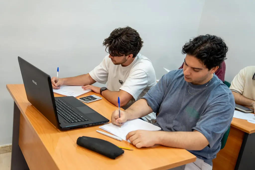 Estudiantes concentrados trabajando en una mesa de la sala de estudio